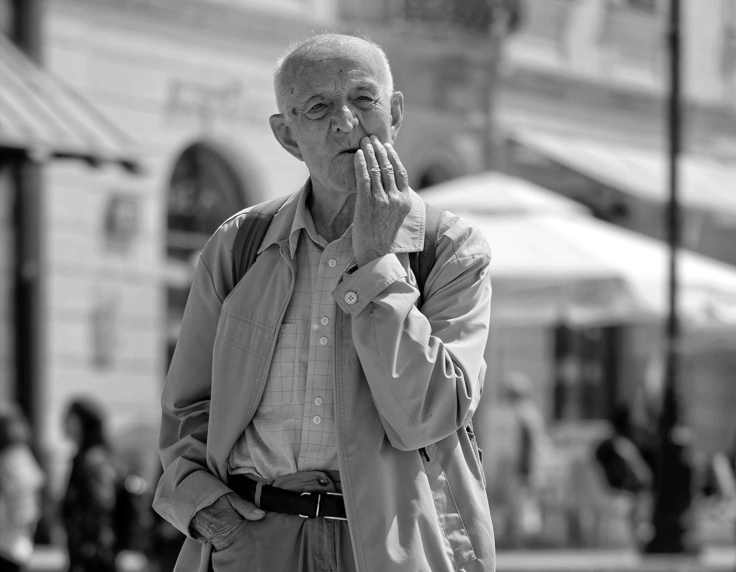 Photo showing older man with hand near mouth