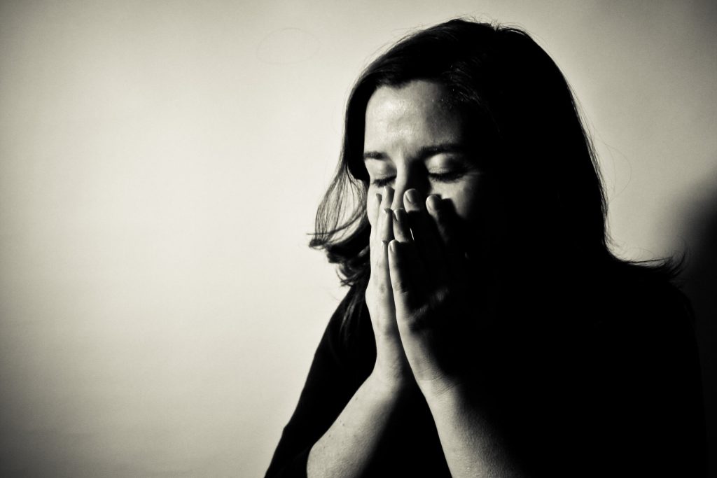 Photo showing a woman with hands to face