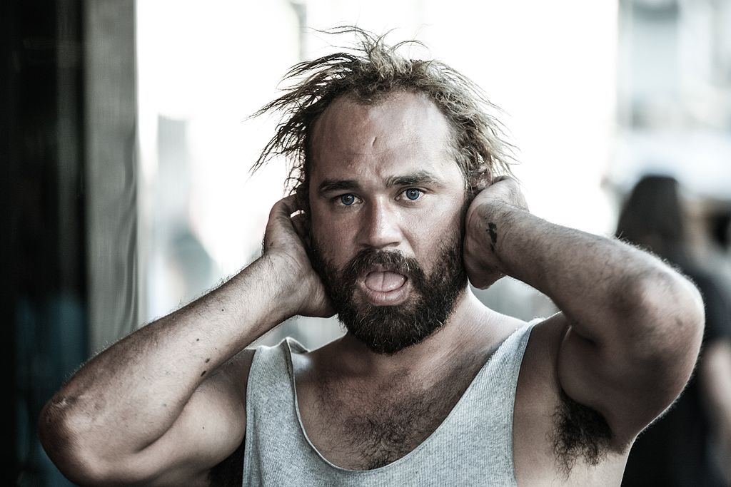 Photo of man with hands over ears an mouth open