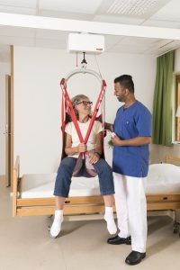 “molift_air_200_rgosling_mb_env_585707.jpg” by unknown author, courtesy of etac.This image is included on the basis of Fair Use. Image showing nurse assisting simulated patient in mechanical lift