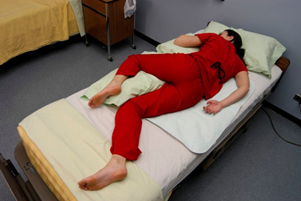 “sims.jpg” by unknown author is licensed under CC BY 4.0. Access for free at https://opentextbc.ca/clinicalskills/chapter/3-4-positioning-a-patient-in-bed/ Image showing simulated patient in sims position