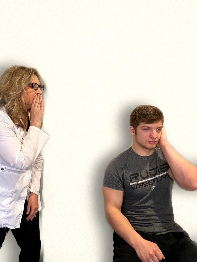 Photo showing a nurse whispering to simulated patient to assess hearing